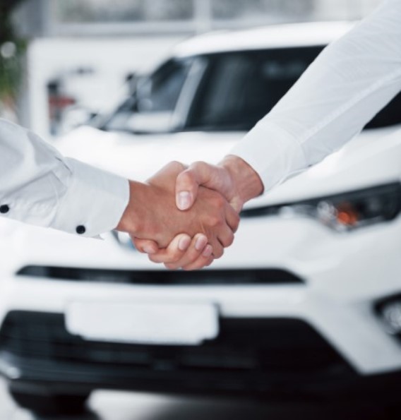 Close up of sales manager in black suit selling the car to the customer.